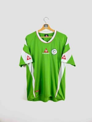 Maillot de foot vintage Algérie Le Coq Sportif, modèle vert avec détails blancs et rouges, logo de la Fédération Algérienne de Football sur la poitrine, édition rétro rare pour supporters et collectionneurs.