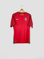 Maillot Portugal 2016 Maillot domicile du Portugal Euro 2016 vu de face, coloris rouge traditionnel avec logo Nike et écusson de la FPF visibles sur la poitrine.
