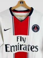 Gros plan sur l’écusson du Paris Saint-Germain figurant sur le maillot collector 2007-08, un élément incontournable pour les fans du club.