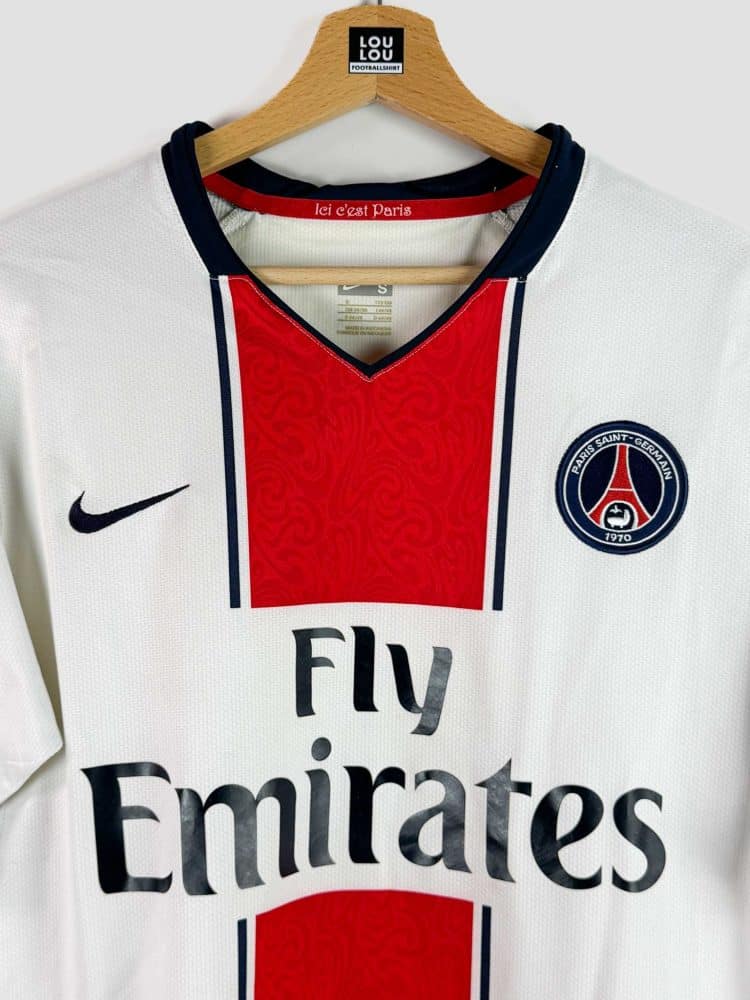 Gros plan sur l’écusson du Paris Saint-Germain figurant sur le maillot collector 2007-08, un élément incontournable pour les fans du club.