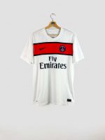 Vue de face du maillot extérieur PSG 2011-2012 (modèle Pastore #27) : tunique blanche à bande rouge horizontale sur la poitrine, avec logo Nike, sponsor Fly Emirates et blason PSG 1970.