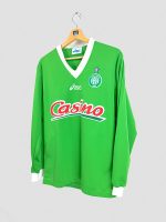 Zoom sur le sponsor Casino sur la poitrine du maillot Saint-Étienne 1998-1999, marquage rouge et blanc.