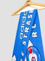 Gros plan sur l'écharpe RC Strasbourg 1996-1997, lettrage adidas et RC STRASBOURG tissés en blanc sur fond bleu Racing vintage.