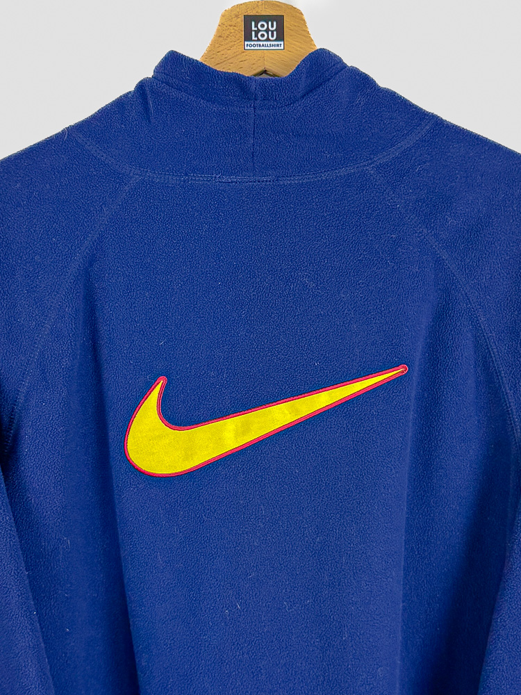 polaire-ancien-fc-barcelone-1998-99-gros-plan-dos-swoosh-col Gros plan sur le swoosh Nike et le col de la polaire ancienne FC Barcelone 1998-99 en fleece bleu