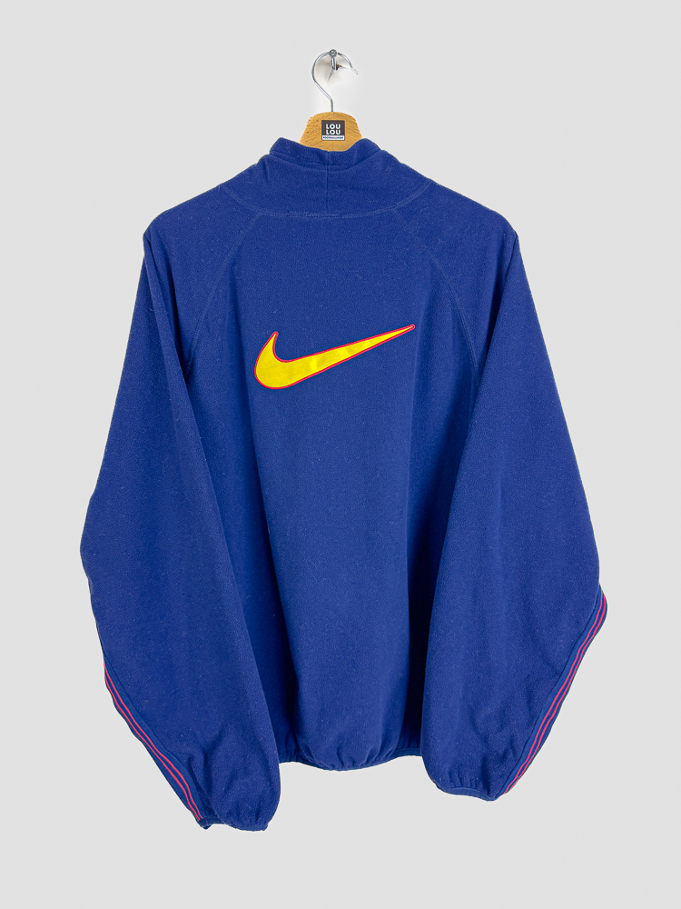 polaire-retro-fc-barcelone-1998-1999-dos-logo-nike-bandes-manches Vue arrière polaire rétro FC Barcelone 1998-1999 montrant le logo Nike et les bandes aux couleurs catalanes